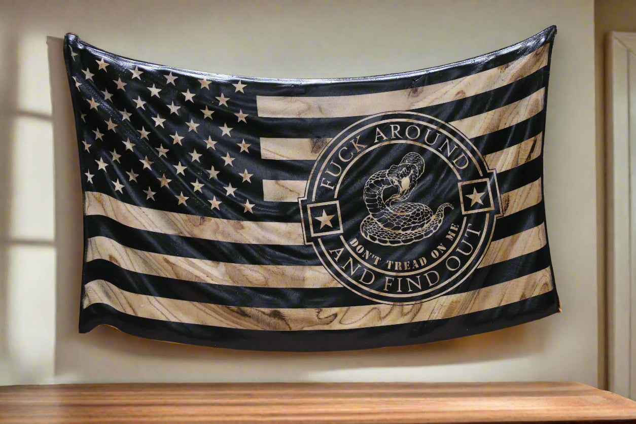 American flag with a snake emblem and text on a wooden surface