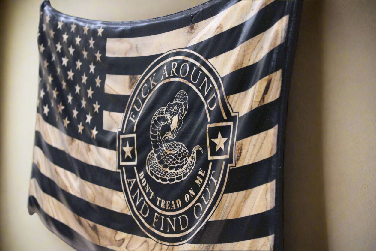 American flag with a snake emblem and text on a wooden surface