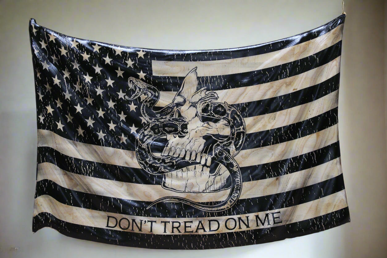 American flag with skull design and 'Don't Tread on Me' text on a wooden surface