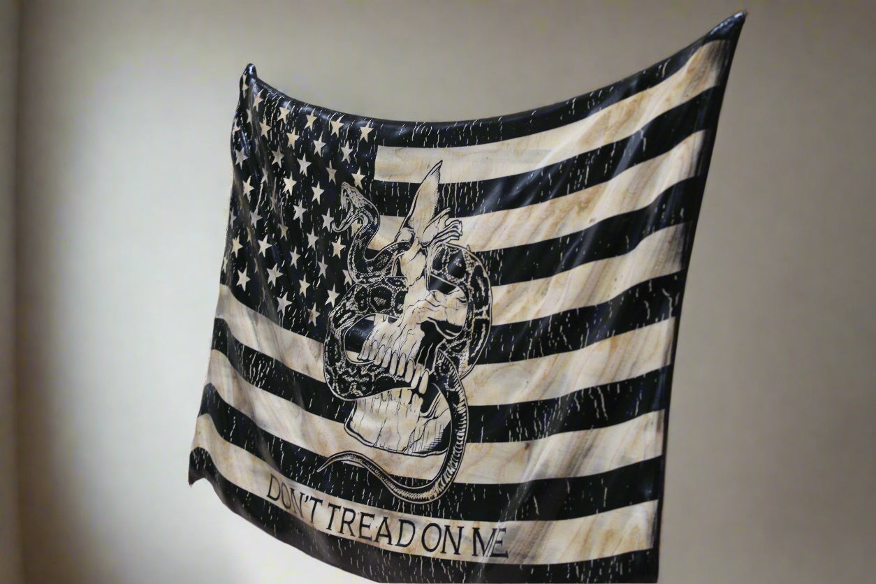 American flag with a skull design and 'Don't Tread on Me' text draped over a wooden surface.