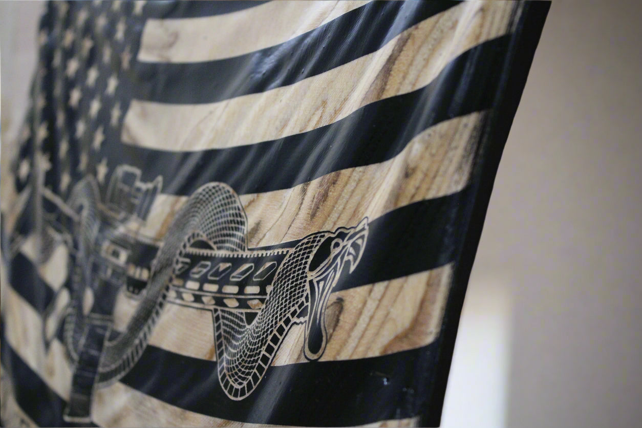 Hand-carved wavy wooden flag, 19.75 x 12 inches, M4 rifle and coiled snake design