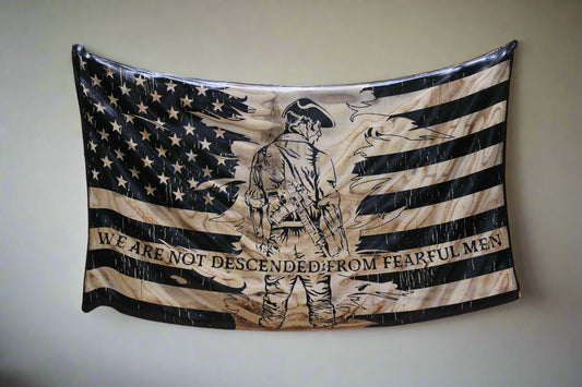 Wooden flag with engraved design and text on a wooden surface